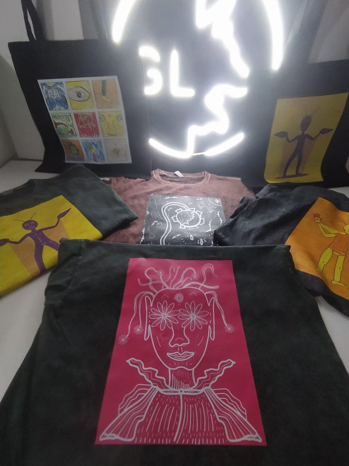 Diseño y serigrafía de playeras negras y blancas con el logotipo de Oasis. Servicios textiles para merchandising y marcas.